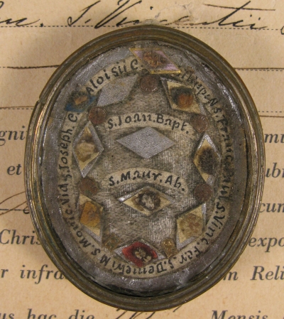 Documented theca with relics of St. John the Baptist and other saints: St. Maurice Abbot, St. Philip Neri, St. Francis of Paola, St. Vincent Ferrer, St. Demetrios Martyr, St. Monica of Hippo, St. Joseph of Cupertino &amp; St. Aloysiu